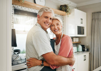 爱拥抱高级夫妇厨房烹饪晚餐快乐首页享受退休首页浪漫婚姻女人拥抱浪漫的高级合作伙伴大微笑