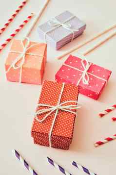假期色彩斑斓的礼物盒子包装色彩斑斓的纸弓米色背景