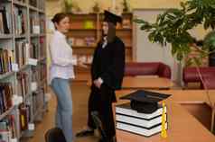 特写镜头毕业帽堆栈书图书馆老师年轻的女研究生背景