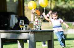 眼镜饮料古董表格聚会，派对快乐孩子们运行黄色的气球模糊背景