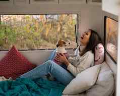 高加索人女人坐着的拥抱狗杰克罗素梗旅行露营者秋天