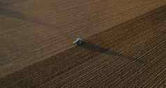 )意大利9月农民开车拖拉机深耕作土地日落