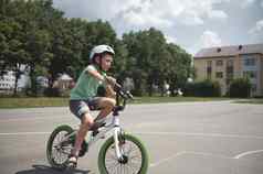 活跃的运动男孩体育头盔自信地骑自行车高加索人学校年龄孩子骑自行车城市沥青路