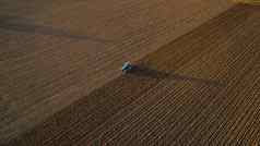 )意大利9月农民开车拖拉机深耕作土地日落
