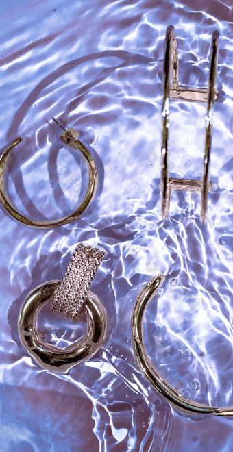 金手镯耳环环Jewelery紫色的水背景奢侈品魅力假期美设计珠宝品牌广告