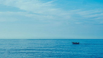 简单的背景平静黑暗蓝色的海钓鱼船白色苍白的浪花<strong>云</strong>开放限制