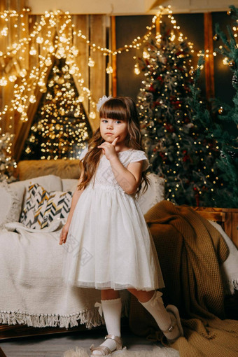 女孩节日光衣服圣诞节树灯花环背景概念一年假期