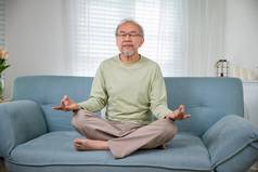 亚洲男人。练习瑜伽冥想莲花位置关闭眼睛