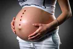 怀孕了女人爱的未出生的婴儿怀孕了胃新生儿婴儿靴女人显示肚子出生靴子怀孕概念