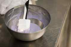 蛋糕设计师准备淡紫色巧克力酱填充白色巧克力滴晶片