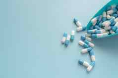 蓝色的白色胶囊药丸塑料勺子蓝色的背景抗生素药物电阻抗菌胶囊药片制药行业药店药店产品制药学