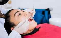 关闭牙科专家清洁病人的牙齿关闭专业牙医清洁女病人牙齿一边视图牙医清洁女病人牙齿复制空间