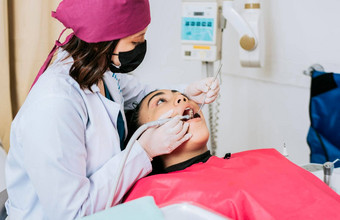 牙科专家清洁牙齿女病人专业牙医清洁女病人的口女牙医清洁检查女病人的口