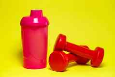 红色的哑铃粉红色的瓶彩色的背景体育能源喝健身房设备