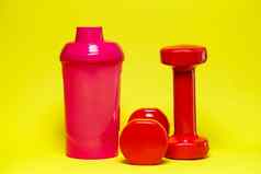 红色的哑铃粉红色的瓶彩色的背景体育能源喝健身房设备