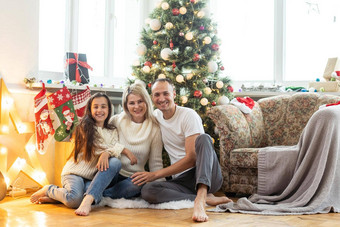 圣诞节家庭幸福肖像爸爸妈妈女儿坐着首页圣诞节树
