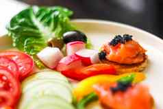 开胃菜盘大马哈鱼黑色的鱼子酱切片新鲜的蔬菜热情好客美食