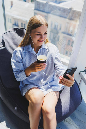 年轻的经理女人耳机会说话的电话喝咖啡坐着现代共同<strong>办公空间</strong>自由女孩工作远程在线