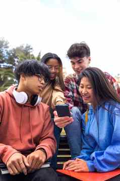 多民族的快乐年轻的大学学生朋友移动电话青少年智能手机户外垂直