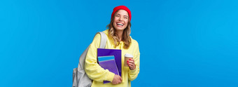 快乐的快乐女学生有趣的享受大学生活方式携带背包笔记本电脑喝外卖咖啡会说话的<strong>同学</strong>们站蓝色的背景快乐的