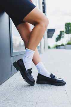 女腿皮革鞋子白色袜子黑色的鹿皮软鞋黑色的短裤时尚细节