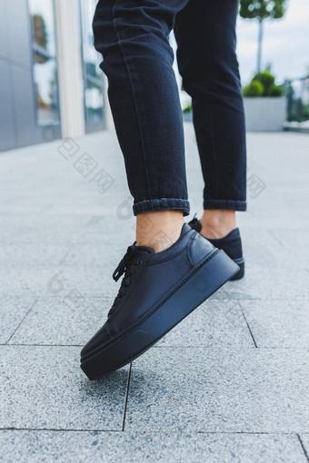 女腿黑色的牛仔裤黑色的系带的鞋子黑色的皮革鞋子特写镜头