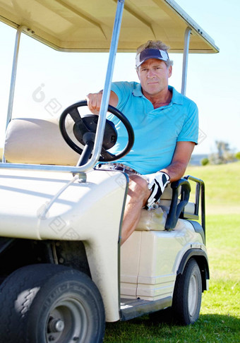 洞成熟的男人。开车高尔夫球车