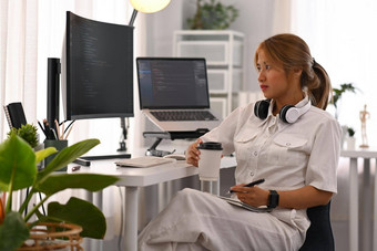年轻的女<strong>程序员</strong>工作编码数据桌面电脑明亮的现代办公室