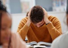大学研究累了学生阅读书类研究测试考试教育压力倦怠男人。头疼知识奖学金学习大学工作图书馆