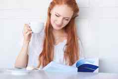 享受放松好书有吸引力的年轻的女人阅读书喝咖啡