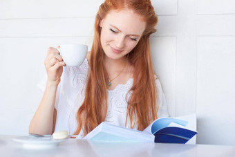 享受放松<strong>好书</strong>有吸引力的年轻的女人阅读书喝咖啡