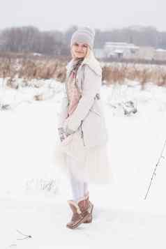 金发女郎女孩冬天衣服走雪草原微笑女人光衣服冬天雪