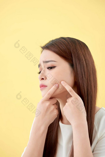 脸皮肤问题年轻的女人不开心触摸皮肤孤立的概念皮肤护理亚洲