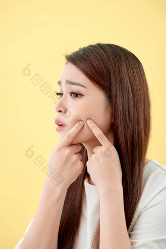 脸皮肤问题年轻的女人不开心触摸皮肤孤立的概念皮肤护理亚洲