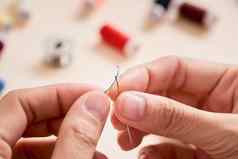 人刺绣缝纫裁剪概念裁缝女人线程针缝合织物手缝纫针线程手指拉线程针