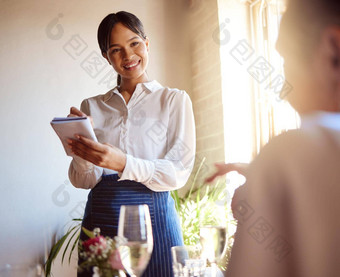 女服务员笔记本写作食物订单客户服务工作室内餐厅快乐女人服务员微笑听服务客户端写讨论菜单热情好客