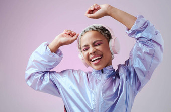 跳舞时尚女人耳机听音乐跳舞紫色的工作室背景非洲美国女微笑音频流媒体享受声音好玩的自由的态度