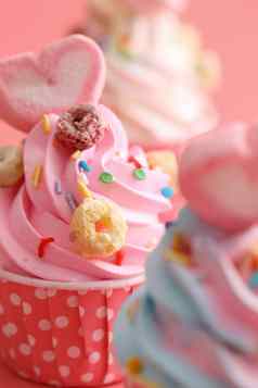 色彩斑斓的纸杯蛋糕孤立的粉红色的背景