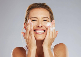 护肤品清洁脸肖像女人洗皮肤美治疗工作室快乐微笑健康的成熟的夫人健康卫生护理生活方式面部例程