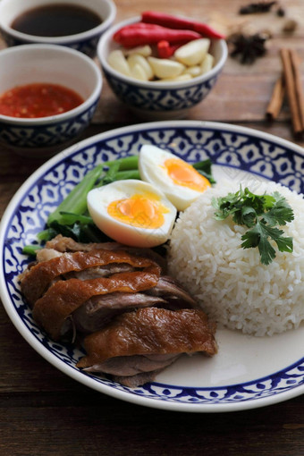 当地的泰国食物红烧猪肉腿大米孤立的木背景