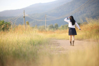 亚洲高学校女孩学生走农村日出