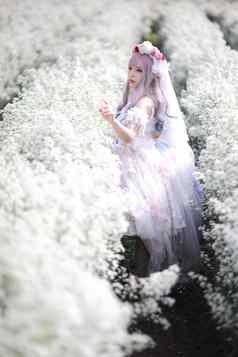 美丽的年轻的女人白色洛丽塔衣服花花园日本时尚
