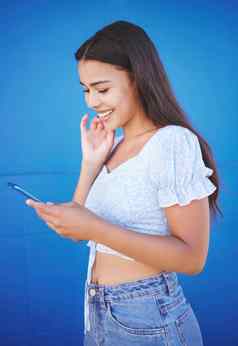 电话社会媒体沟通女人蓝色的背景网络连接应用程序微笑移动技术女约会在线发送文本消息