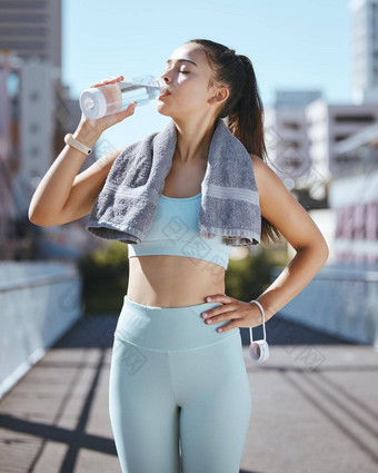 女人水瓶健身城市休息喝毛巾夏天早....澳大利亚健康锻炼女孩跑步者采取时间休息户外城市锻炼