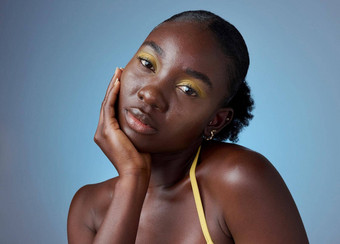 脸化妆有创意的肖像黑色的女人发光化妆品蓝色的模型工作室背景非洲模型美化妆品艺术清洁身体护理模拟空间