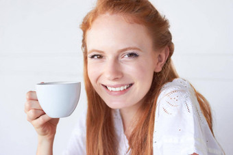 享受早....杯肖像有吸引力的年轻的女人喝杯咖啡