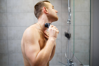男人。刮胡子脸电<strong>剃须刀</strong>前面镜子皮肤刺激浴过程