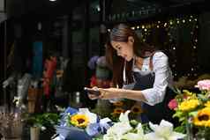漂亮的女人花店采取照片完成了花花束社会媒体花卉栽培技术业务技术概念