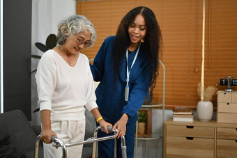 有爱心的护士参加帮助上了年纪的女人走框架沃克首页首页健康护理服务概念