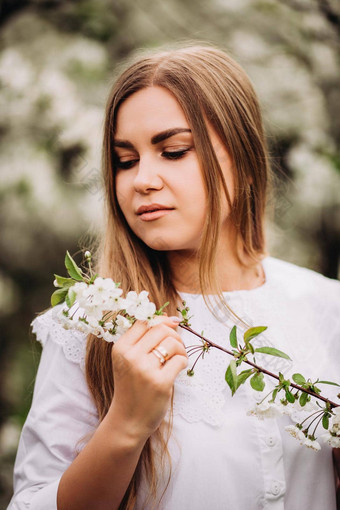 肖像金发的年轻的女人白雪公主衣服站开花苹果树女孩走盛开的苹果果园春天